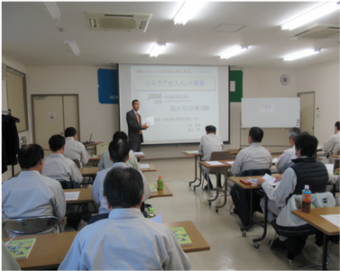 リスクアセスメント研修の様子。教室内で講師の話を聞いている写真