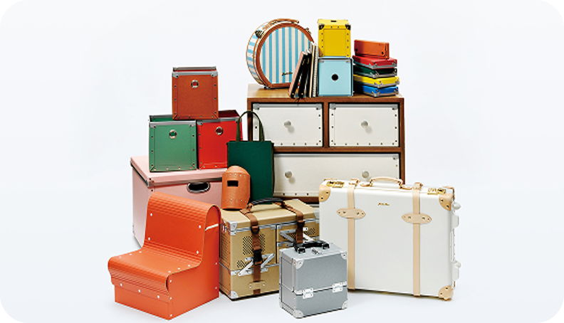 Processed product samples, including a suitcase and chair, made from specialty paper and functional materials.