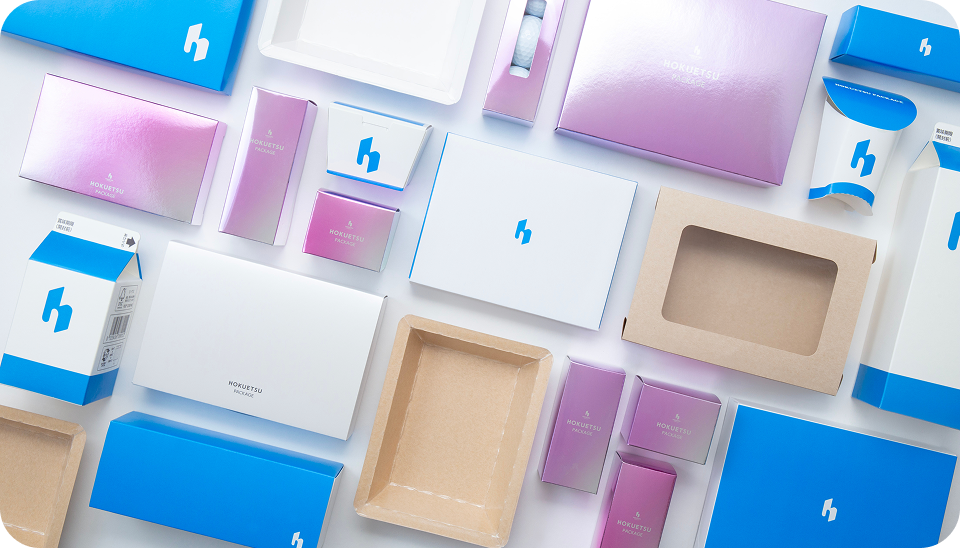 Various product examples using white paperboard, such as gift boxes and food containers.