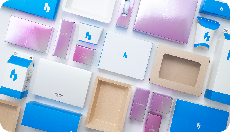 Various product examples using white paperboard, such as gift boxes and food containers.