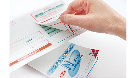 圧着されたはがき用紙をめくっている写真