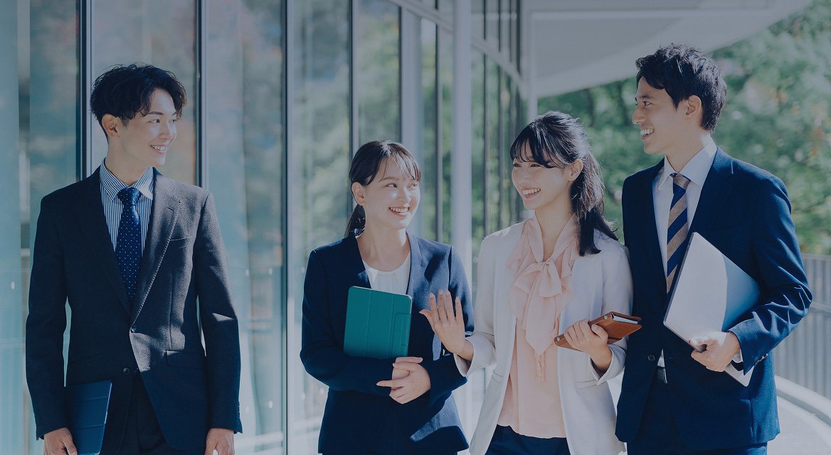 スーツを着ている男性と女性が、屋外で話しながら歩いている写真。